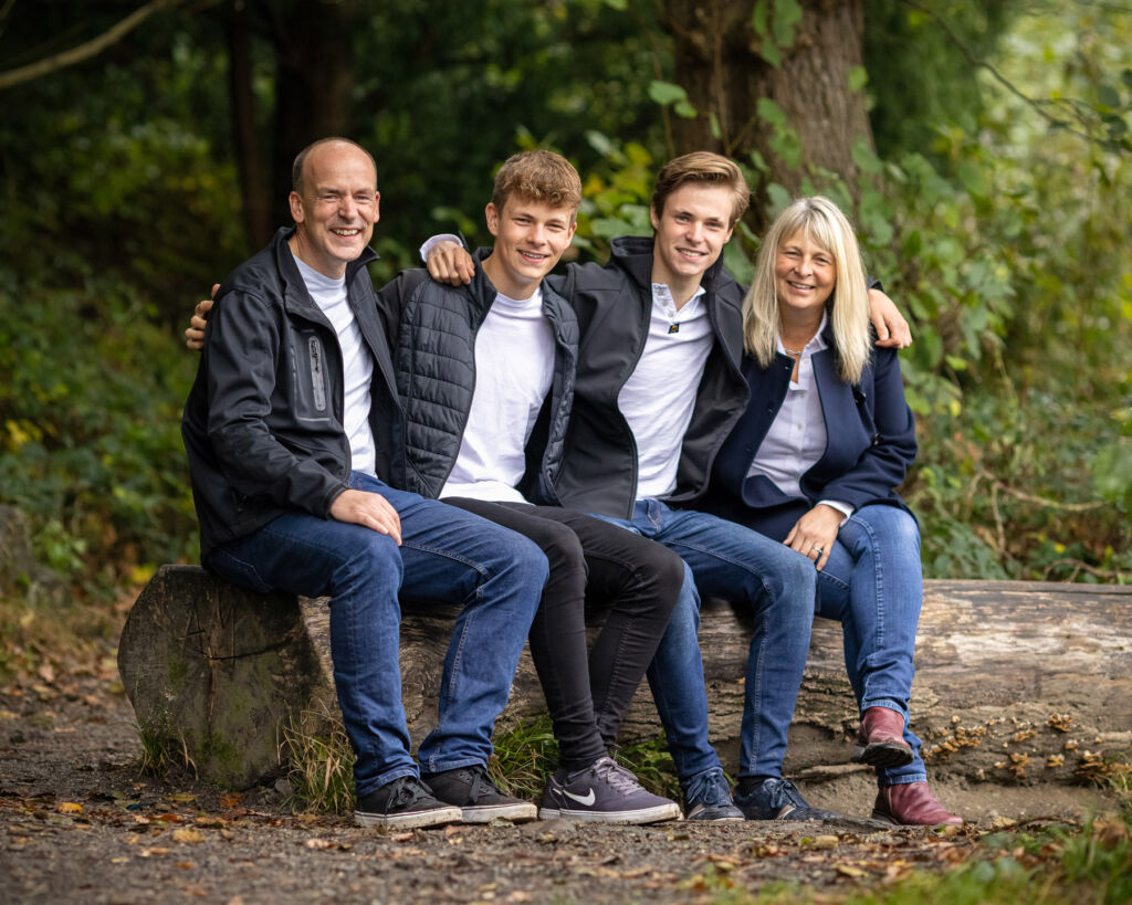 Paul sitting on a log with his family