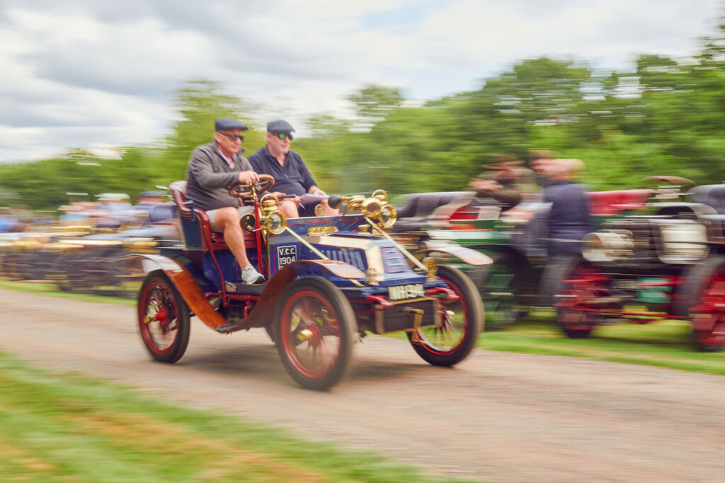 One of the classic cars motoring at speed in front of excited spectators