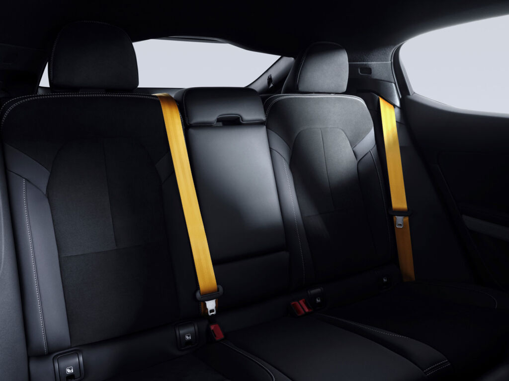 A photograph of rear seats with yellow seatbelts