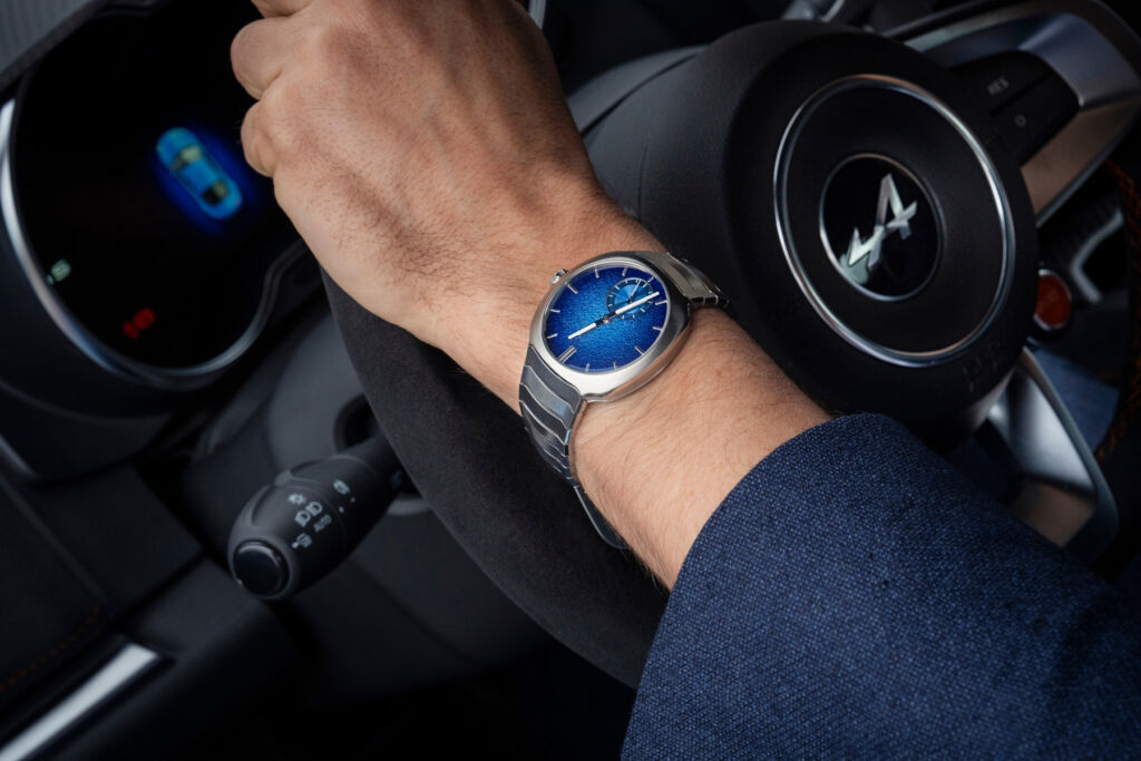 One of the company timepieces next to an Alpine car steering wheel