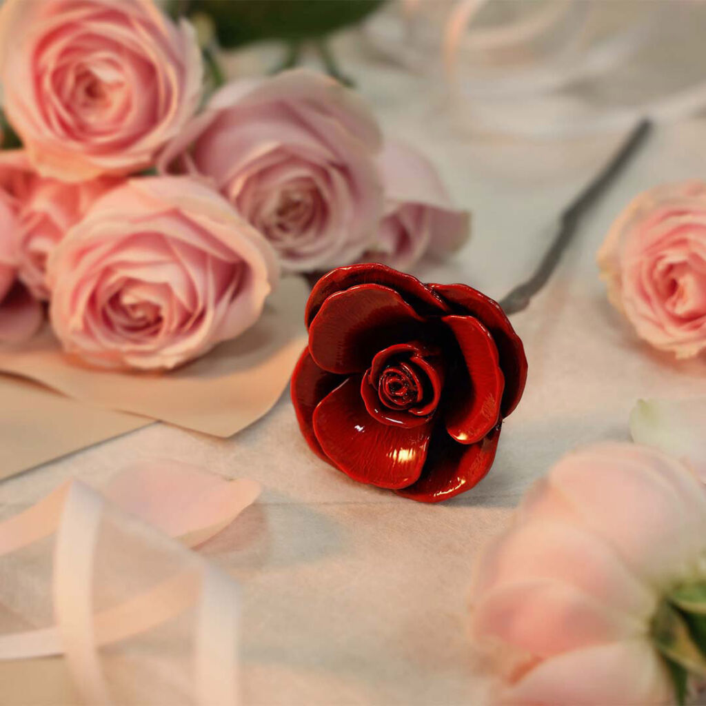 The red rosa blossom laid on a table next to fresh pink roses 