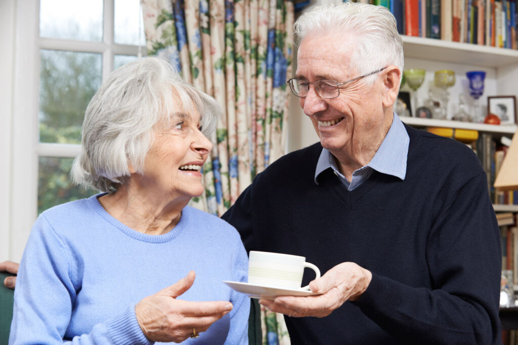 An older couple enjoying a laugh over a cup of tea