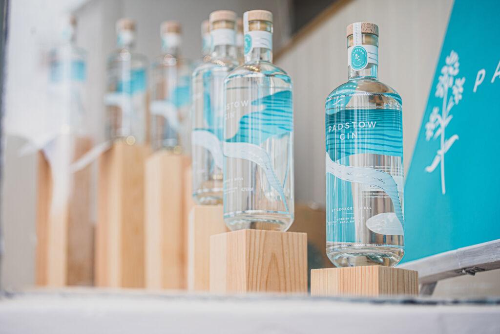 Light blue labelled glass bottles of gin on wooden blocks