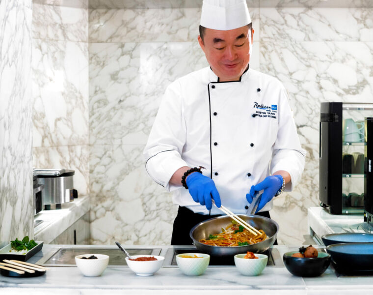 A chef preparing traditional Chinese food dishes
