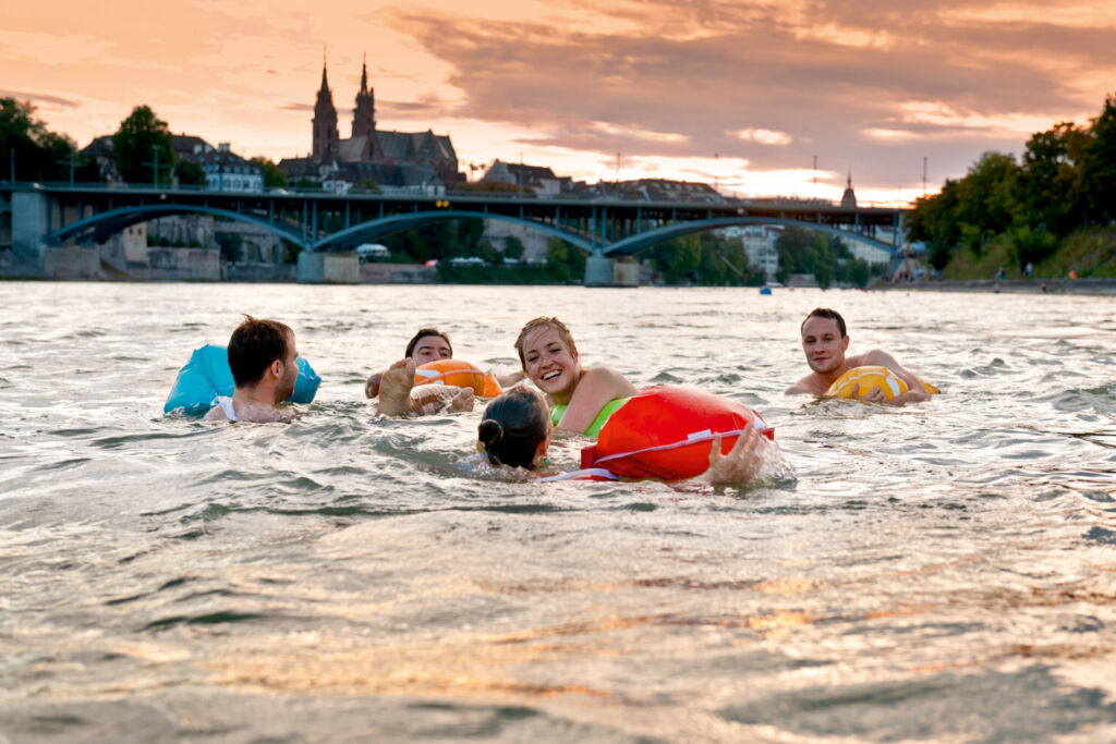 A family wearing floatation devices swimming in the river