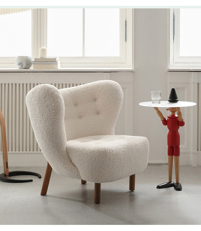 The Thierry chair nest to a side table which is being held by a wooden figure