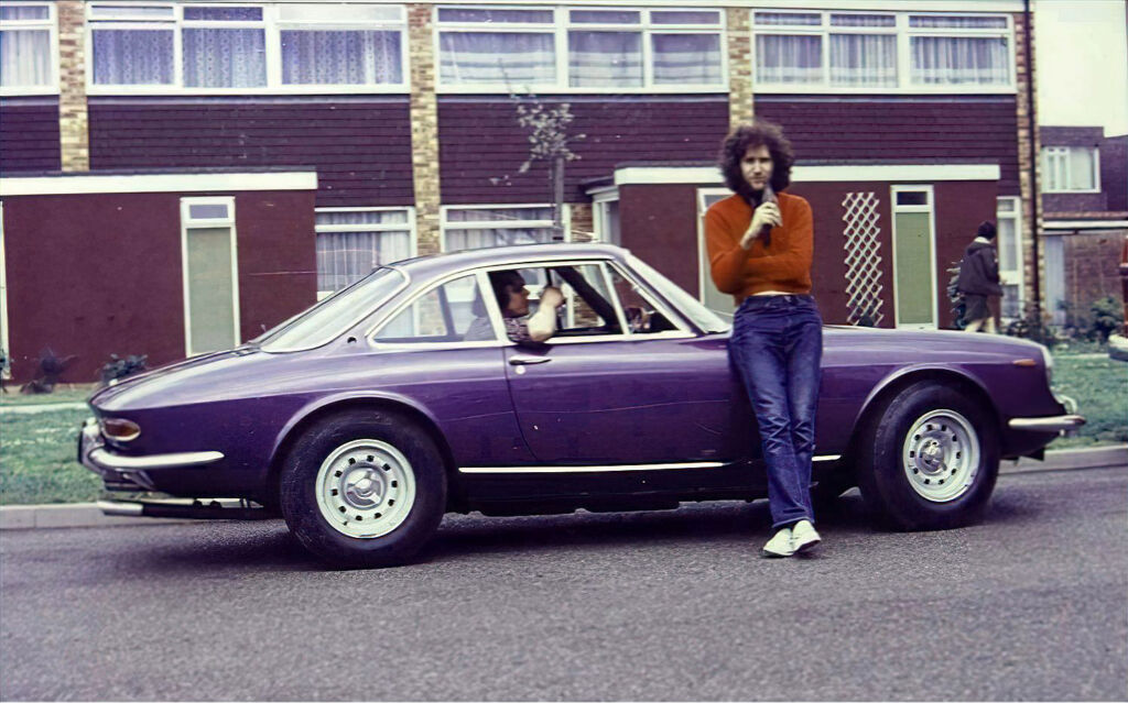 Eric Clapton leaning on his purple coloured Ferrari