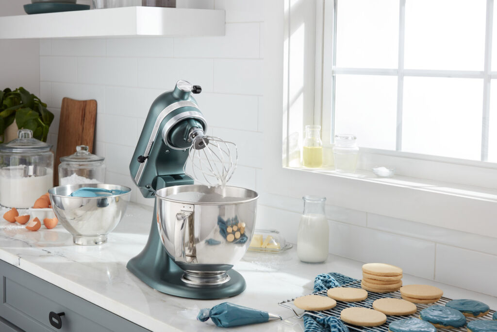 The mixer on a kitchen worktop, with its head tiled back next to some freshly baked Juniper coloured biscuits