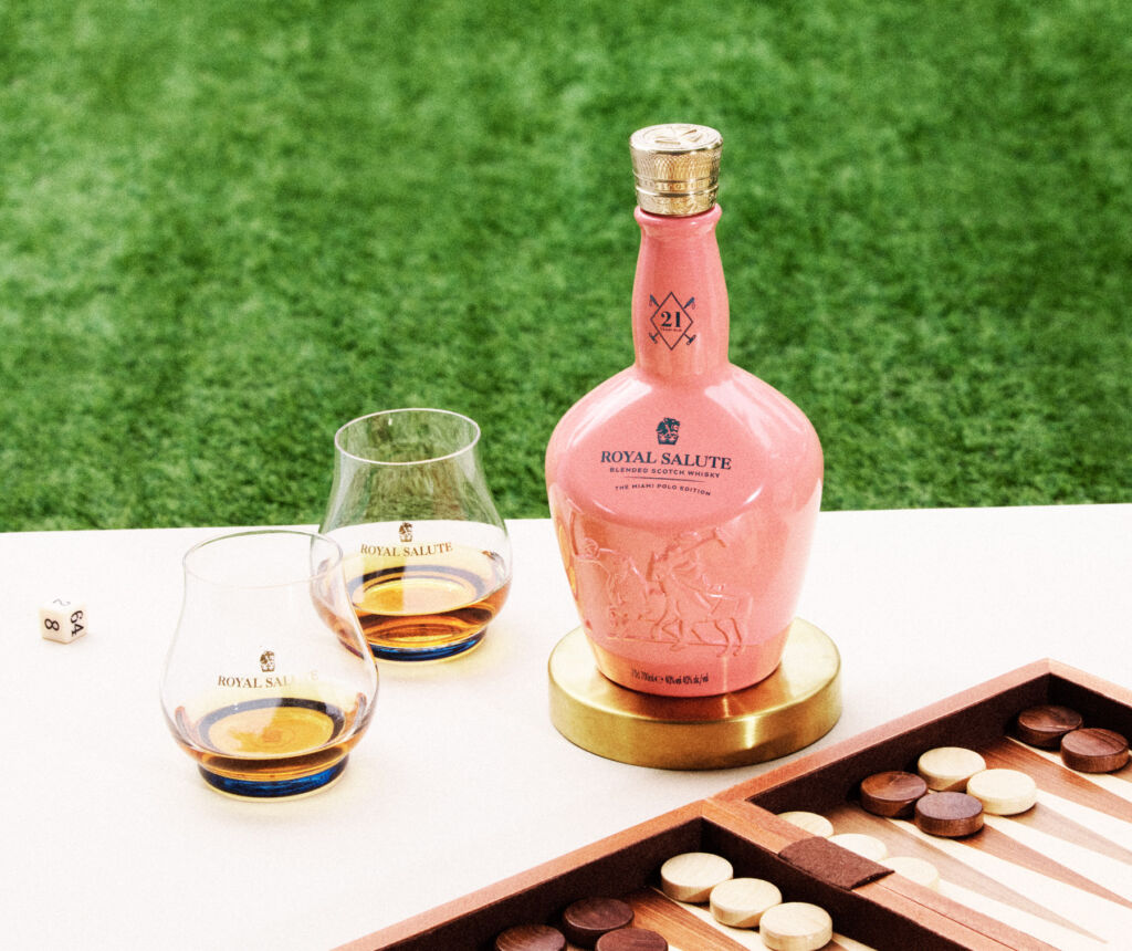 A photograph of the 21 Year Old Miami Polo Edition in its pink coloured flagon next to a backgammon set