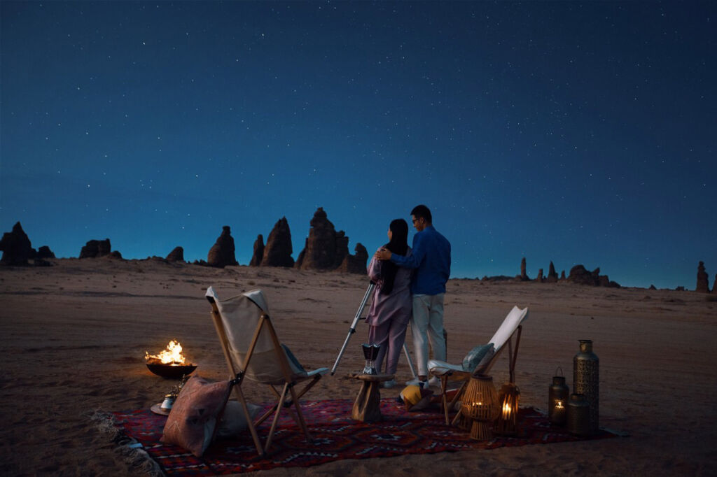 Jeddah to AlUla: Seven New Luxury Hotels to Discover Saudi’s Rich Tapestry 18 A couple stargazing at night by a campfire