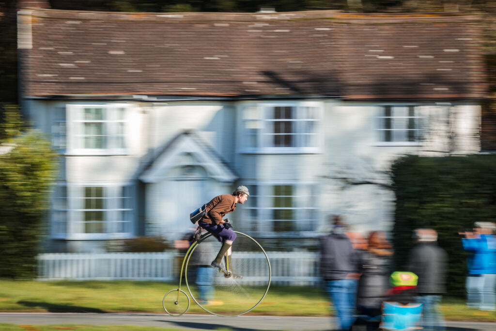 A cyclist speeding along on a Penny Farthing bicycle