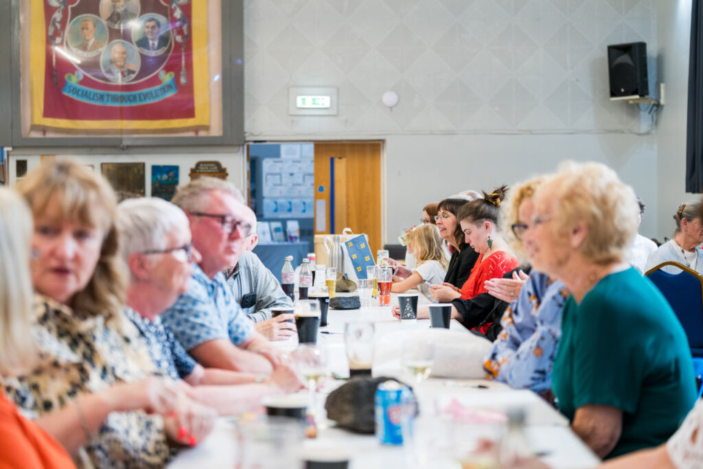 People sitting at tables at the listening party