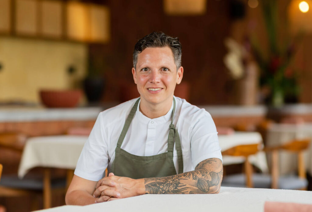 A smiling Syrco sitting in his restaurant