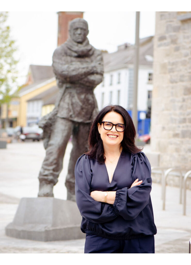 Aline Fitzgerald standing in front of a statue of the explorer