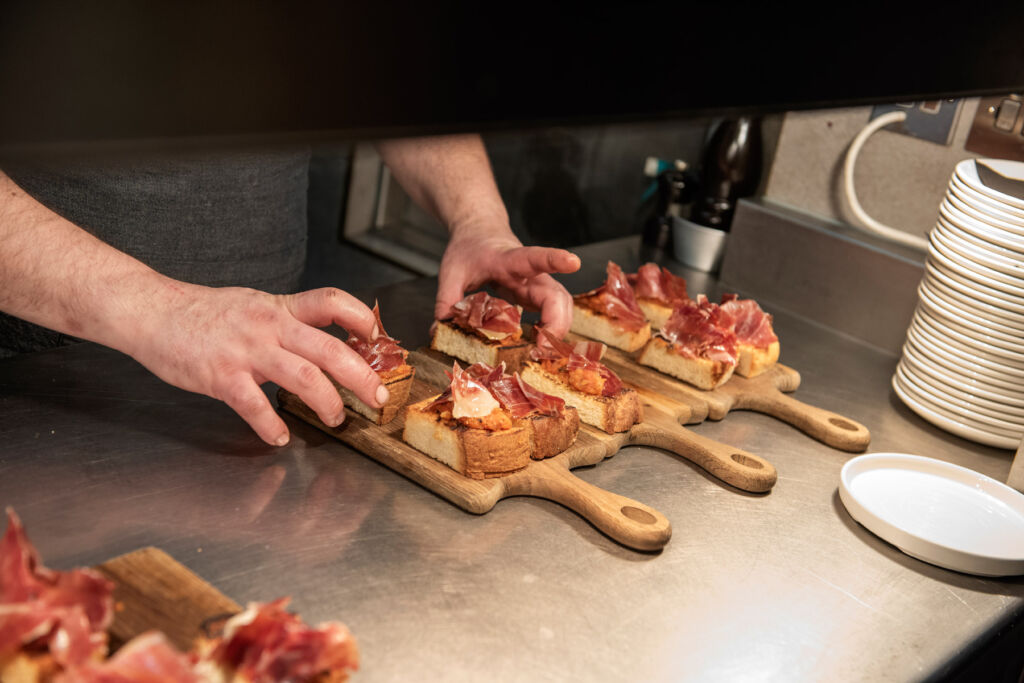 Omar Allibhoy Brings the Soul of Ibérico Ham to British Tables 15 Slices on ham being assembled on wooden boards