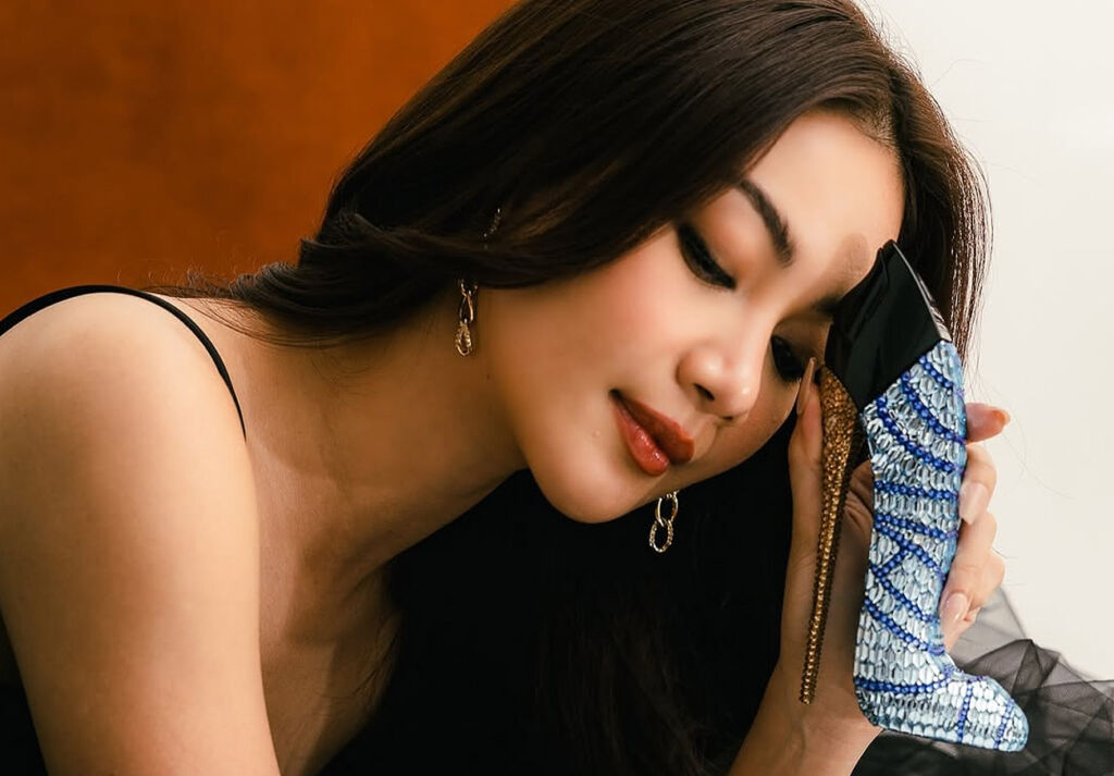 Edição de colecionador The Good Girl Superluxe: Ode à feminilidade ousada de Carolina Herrera 8 Trisha segurando o precioso frasco de perfume contra a testa