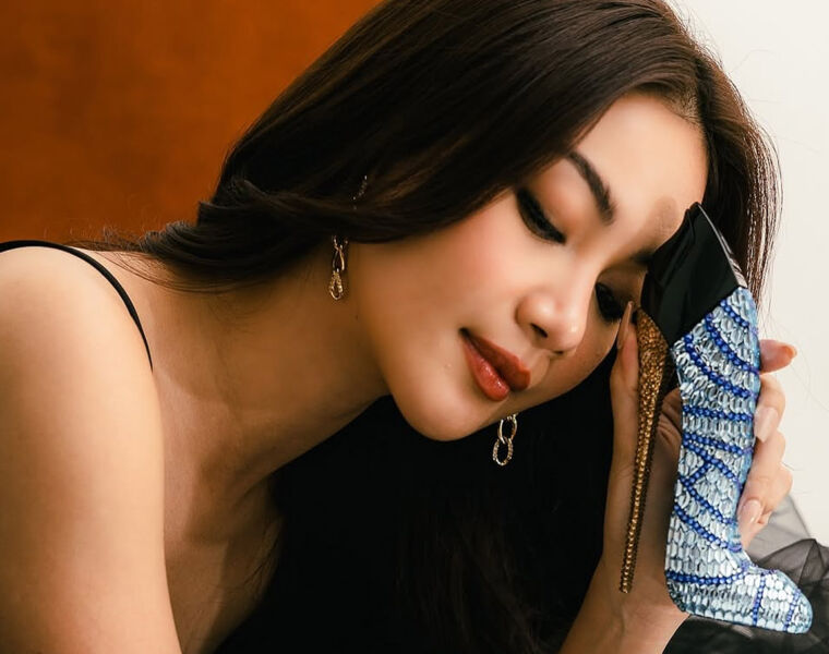 Trisha holding the precious perfume bottle against her forehead