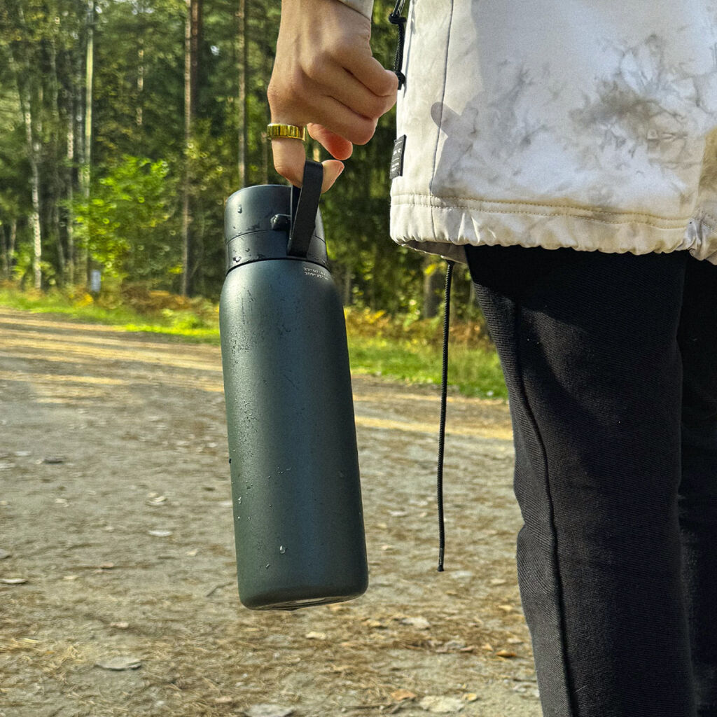 A hiker carrying a green coloured bottle