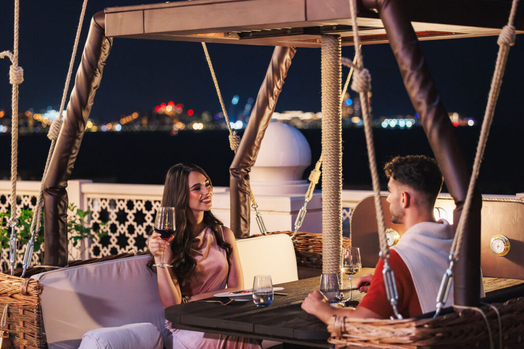 A Majestic Journey Awaits: Balloons at the Palace Returns with Arabian Skies 9 A couple relaxing in a balloon in the evening