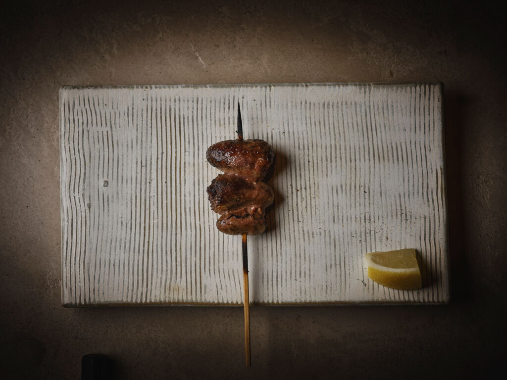 A meat skewer with a slice of lemon