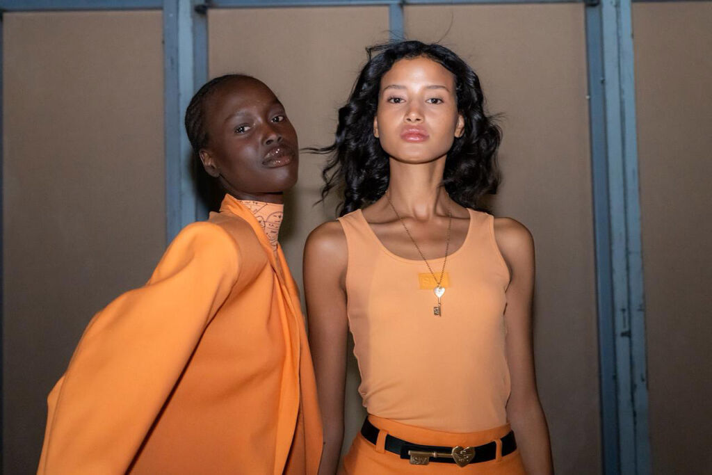 A couple of models wearing orange coloured garments