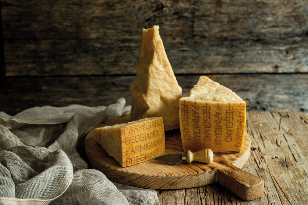 Slices of the renowned cheese on a wooden board atop a a rustic table