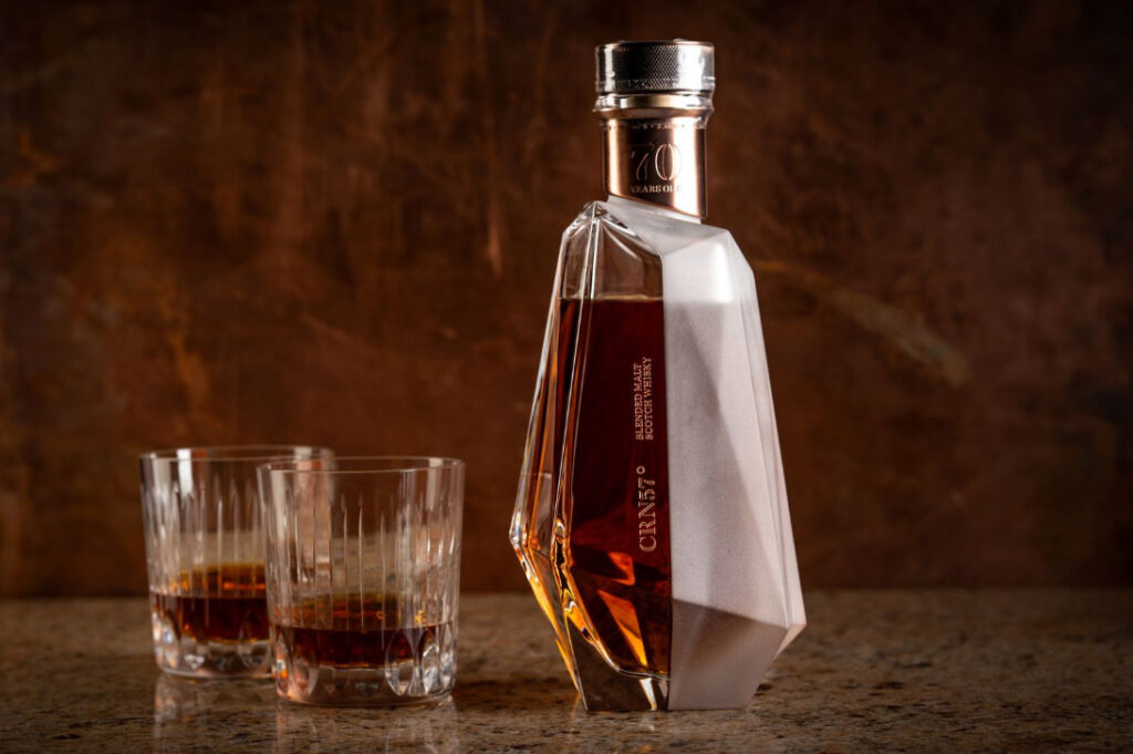 A bottle of CRN57° next to two semi-filled crystal glasses