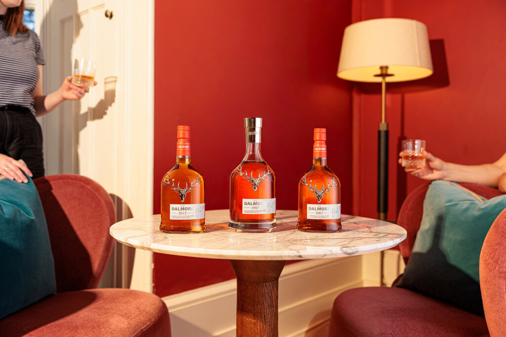 Three bottles from the Select Series on a marble-topped side table in a living room